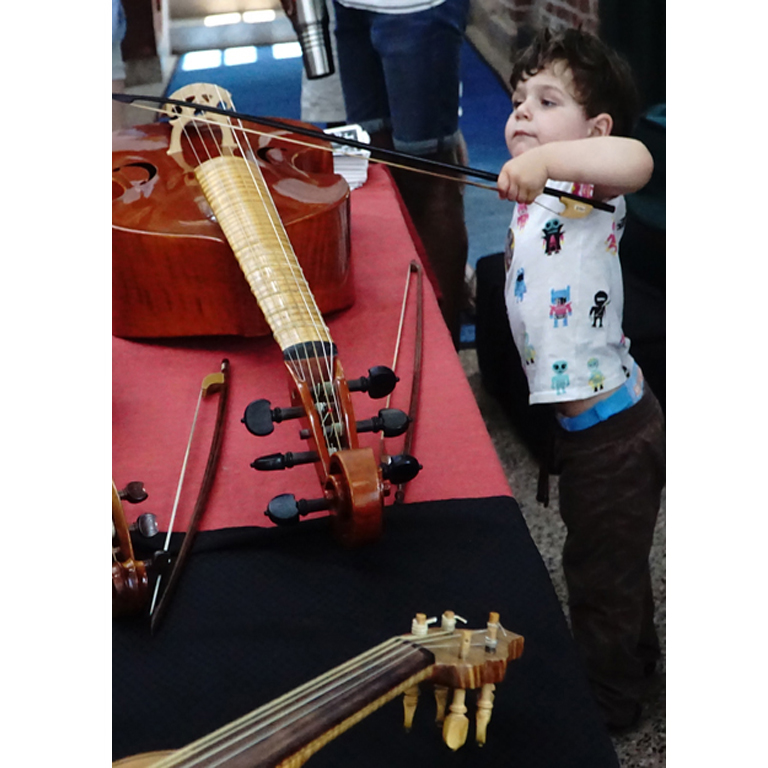 child playing at the instrument petting zoo